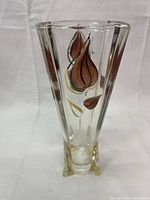 Front view of the clear glass vase showing the brown floral design and square base.