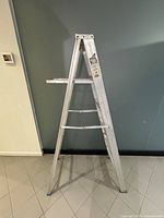 Side view of 5ft aluminum folding ladder showing five steps and platform tray with Reynolds label visible.