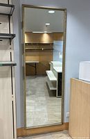 Full length rectangular mirror mounted on wall, showing full mirror and its surroundings.