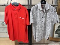 Front view of both shirts on hangers; red Bugatchi polo and patterned 7 Downie St shirt with elephant design.