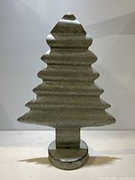 Front view of galvanized metal Christmas tree shape with a corrugated texture and round base.