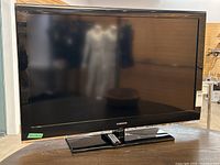 Front view of Samsung 44 inch TV showing the large flat screen and stand with remote.