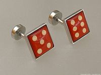 Pair of Würkin Stiffs silver metal cufflinks with red enamel dice faces, showing the top and front view