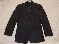 Full view of the black Armani blazer jacket laid flat, showing front buttons, lapels, and sleeves.