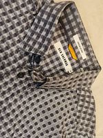 Close-up of the collar area showing the Ben Sherman label and circular geometric pattern in gray and black.