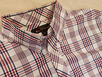 Close-up of the top half of the short-sleeved plaid shirt showing button-up detail and collar with Ben Sherman label indicating medium size.