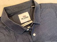 Close up of collar and Ben Sherman brand label showing 'Slim Fit Cotton Midweight'