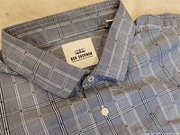 Close-up image showing blue plaid pattern shirt collar with Ben Sherman label inside, white buttons visible.