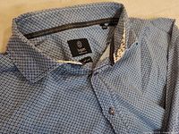 Close-up of Bugatti label, collar and fabric pattern showing classic geometric design and fabric detail.