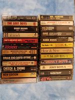 Photo showing two stacks of cassette tapes arranged side by side. Titles and artists are visible on tape spines.