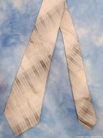 Front and full length view of the beige and gray striped silk necktie with diagonal patterns on a blue background.