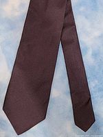 Close-up of front of the dark Hugo Boss silk necktie showing its texture and color.