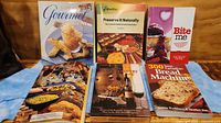 Set of 6 colorful cookbooks on a table with various food recipes and themes