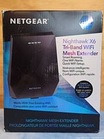Box of Netgear Nighthawk X6 Tri-Band WiFi Mesh Extender showing product name, features, and branding.