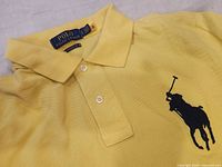 Close-up highlighting large black horse logo embroidered on chest above the buttons.