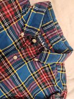 Close-up of the collar and buttons showing Ralph Lauren label and plaid fabric detail in blue, red, yellow, and black colors.