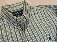 Close-up view of the shirt's upper front area showing the Ralph Lauren label, plaid pattern, button-down collar, and embroidered blue pony logo.