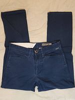 Full front view of folded navy blue Volcom pants showing the overall shape and color.