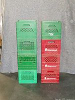 Two stacks of plastic crates: one stack of five green crates (one separate) and one stack of three red crates with Silverwood branding.