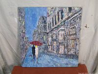 Full view of the painting showing two people under a red umbrella walking on a rainy Paris street with multi-story buildings and impressionist style brushwork.