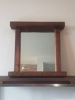 Front view of the 24 x 24 reclaimed barnboard mirror mounted on a wall, showing the rustic wood frame and clean reflective surface.