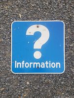 Front view of a vintage metal highway street sign with white question mark and 'Information' text on blue background, showing wear and scratches.