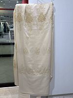 Full view of one sheer curtain panel hung on rod against store interior background