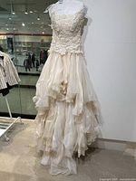 Full front view of strapless wedding gown on form