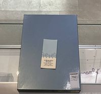 Closed gray-blue box with branded label centered