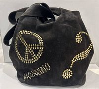 Front view of the Moschino black suede bucket bag showing peace sign, question mark, and Moschino name in gold studs.