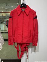 Front view of red Innsbruck ski jacket showing zipper, collar, and adjustable belt