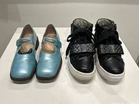 Both pairs of shoes front view showing style and condition on white surface.