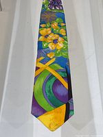 Close-up photo of the silk tie showing the bright multicolour floral pattern and some stains.