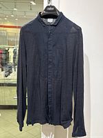 Front view of the black linen shirt showing full length, buttons, and band collar.