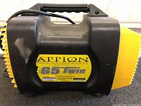 Overall side profile showing black/yellow housing, carry handle, and Appion G5 Twin label.