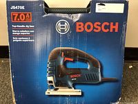 Front view of the closed box showing Bosch JS470E jigsaw image, brand logo, and key features such as the 7.0 amp motor and top handle design.