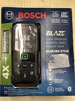 Front of box showing Bosch BLAZE GLM165-27CG laser measure in packaging with 165 ft / 50 m range and 4X brighter laser beam claim.