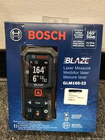 Front view of boxed Bosch BLAZE GLM165-22 Laser Measure showing product display and packaging details.