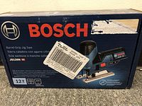 Box front showing Bosch branding, model JS120N, barrel-grip jig saw image, 12V max, 3/4 inch stroke length.