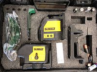 Complete view of DeWALT laser level and accessories inside foam carrying case including protective glasses, mounting bracket, batteries, and green tool.