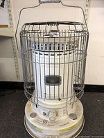 Full view of the Dura Heat portable kerosene heater with safety metal cage, handle, and base showing some minor wear.