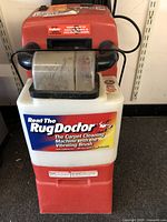 Front view showing the Rug Doctor label on the white fluid tank and visible signs of usage.