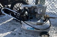 Side view of Webster Curtis Wright commercial air compressor showing motor, piston compressor, mounted on tank with wheels and handle.