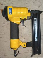 Power Fist air hammer nail gun side view showing trigger, grip, and nail magazine.
