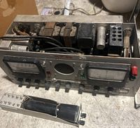 Front view showing analog meters, control knobs, and additional cylindrical component detached in front.