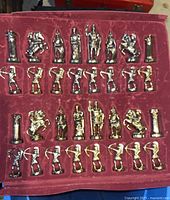 Metal chess pieces arranged in a red velvet case showing classical design details.