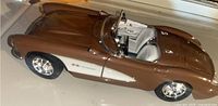 Side view of 1957 Chevrolet Corvette die cast model showing brown paint and white interior