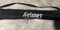 Black fabric carrying case with Selmer logo in white and gold lettering for the folding music stand.
