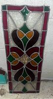 Front view of stained glass panel showing red, green, orange, amber, and clear textured glass design.