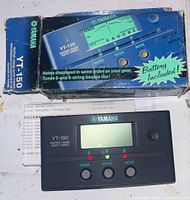 Photo of original box with product image and text showing notes displayed and tuning for 5-6 string basses. Box indicates battery included.